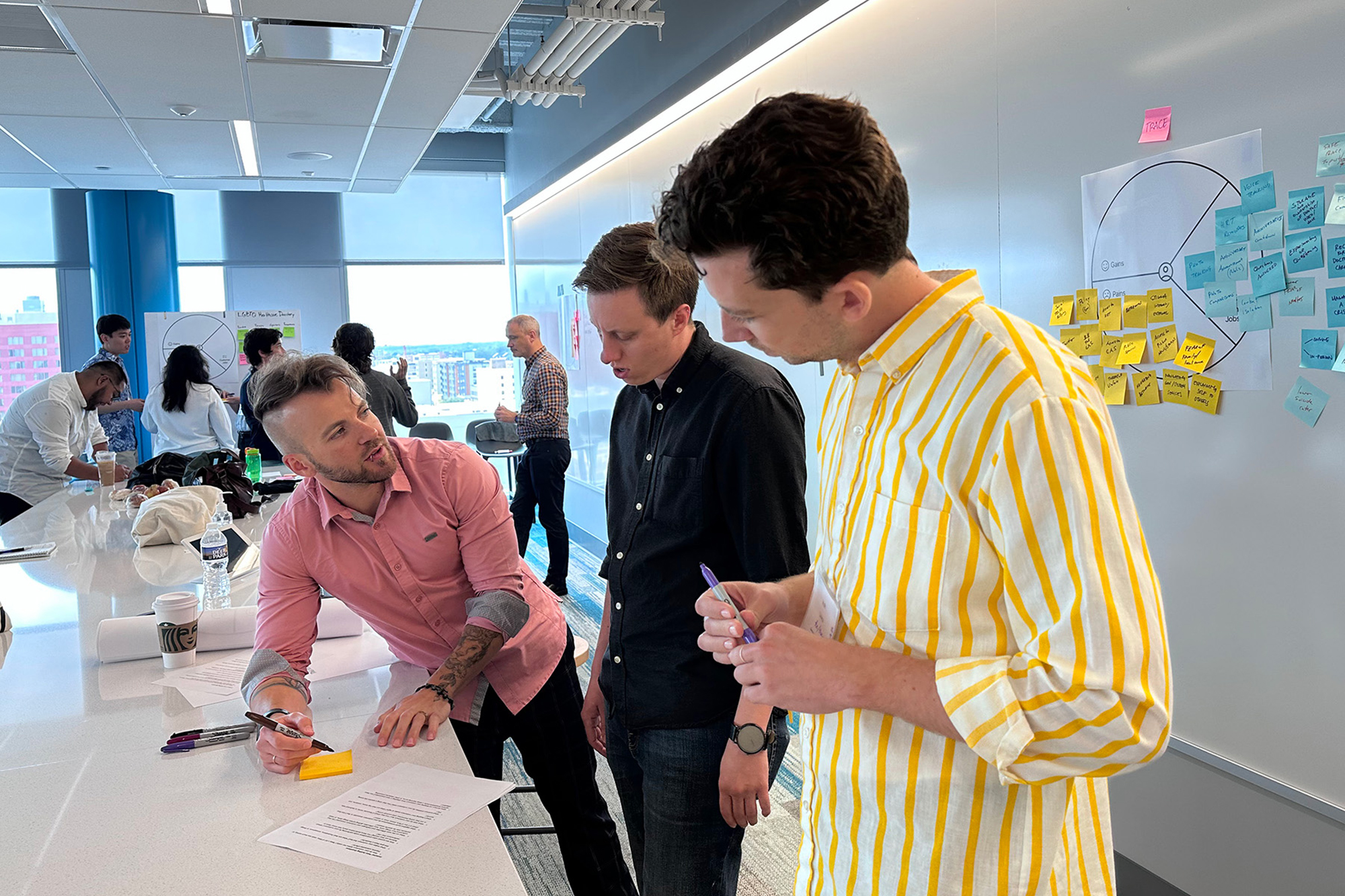 People standing around a long table in a conference room